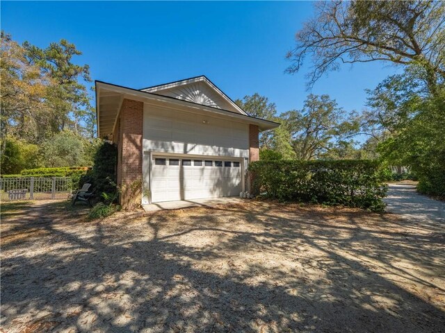 104 Colony Pl, Saint Simons Island, GA 31522 - view of property exterior featuring brick siding and dirt driveway