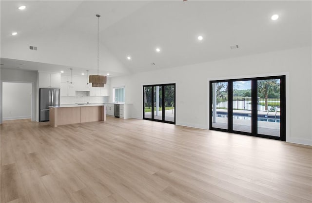 unfurnished living room featuring light hardwood / wood-style floors and high vaulted ceiling