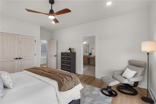 bedroom with a closet, ensuite bathroom, light hardwood / wood-style flooring, and ceiling fan