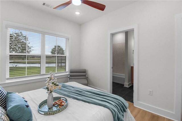 bedroom with connected bathroom, ceiling fan, and hardwood / wood-style flooring