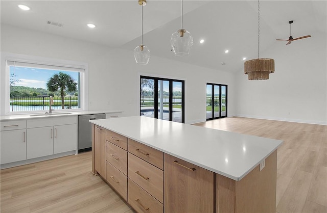 kitchen with pendant lighting, white cabinetry, dishwasher, and a healthy amount of sunlight