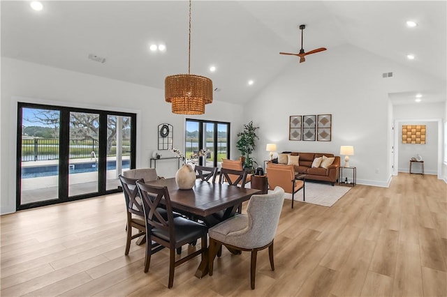 dining room with plenty of natural light, high vaulted ceiling, and light hardwood / wood-style flooring