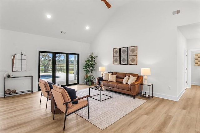 living room featuring ceiling fan, light hardwood / wood-style flooring, high vaulted ceiling, and french doors