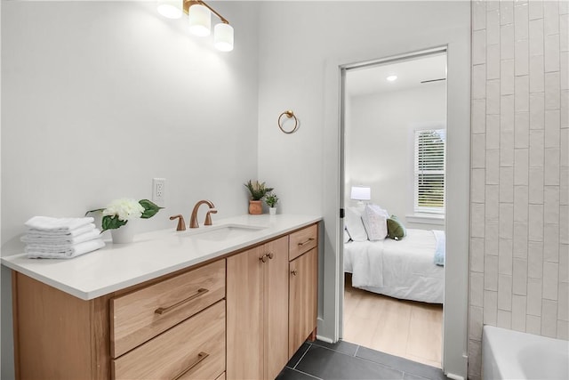 bathroom featuring tile patterned floors, vanity, and a bath