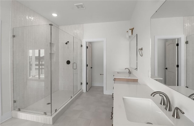 bathroom featuring a shower with door and vanity