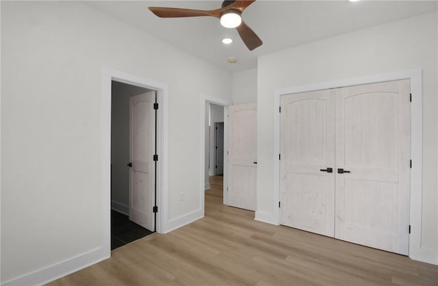 unfurnished bedroom featuring hardwood / wood-style floors, a closet, and ceiling fan