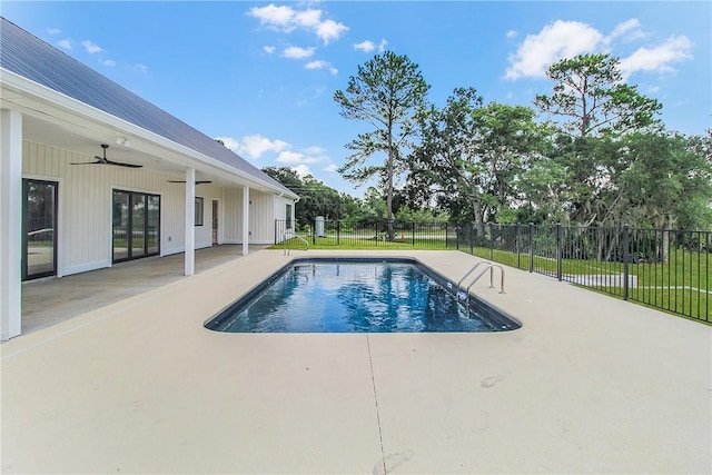 view of swimming pool with ceiling fan, a yard, and a patio