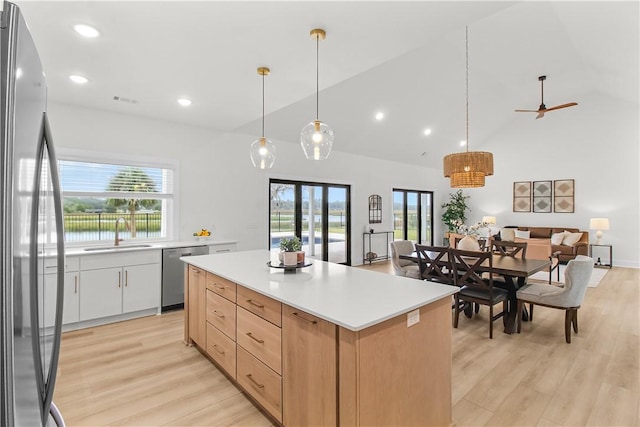 kitchen featuring sink, ceiling fan, appliances with stainless steel finishes, decorative light fixtures, and white cabinetry