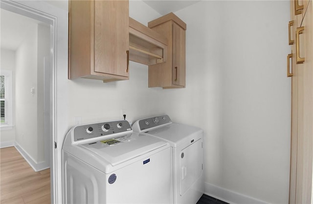 washroom with cabinets, independent washer and dryer, and light wood-type flooring