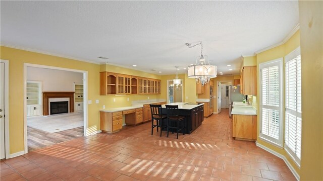 500 Altamaha Rd, Jesup, GA 31545 - kitchen with light countertops, open shelves, crown molding, a glass covered fireplace, and a kitchen island