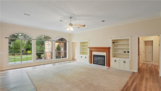 500 Altamaha Rd, Jesup, GA 31545 - unfurnished living room with ornamental molding, plenty of natural light, ceiling fan, a glass covered fireplace, and built in shelves