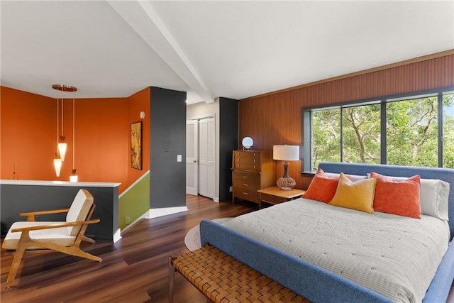 1332 Oak St Unit 9, Saint Simons Island, GA 31522 - bedroom featuring multiple windows, wood finished floors, beamed ceiling, a closet, and wooden walls