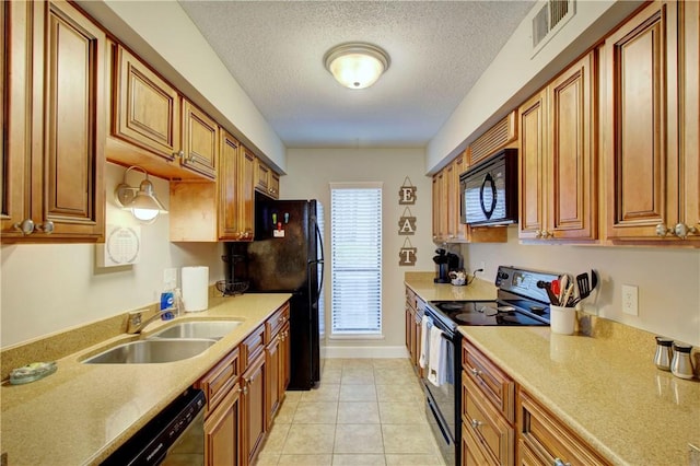 kitchen featuring visible vents, black appliances, light countertops, a textured ceiling, and a sink