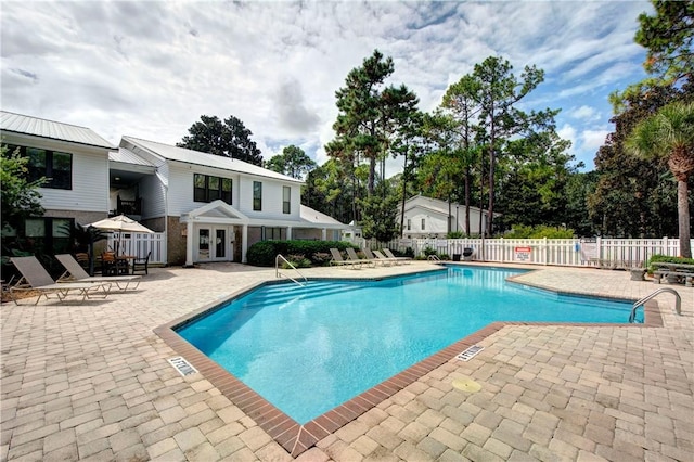 community pool with a patio area, french doors, and fence