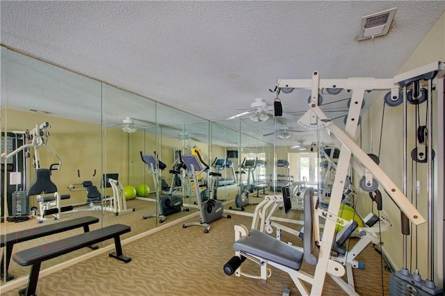 gym with a ceiling fan, visible vents, carpet floors, and a textured ceiling