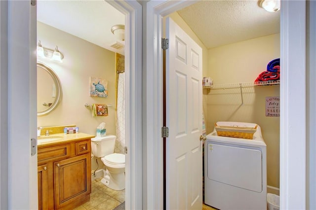 laundry area featuring laundry area, light tile patterned flooring, washer / clothes dryer, a textured ceiling, and a sink