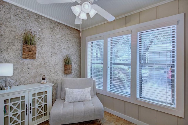 sitting room featuring wallpapered walls, ceiling fan, and ornamental molding