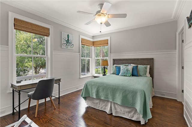 bedroom with crown molding, ceiling fan, wood finished floors, and a wainscoted wall