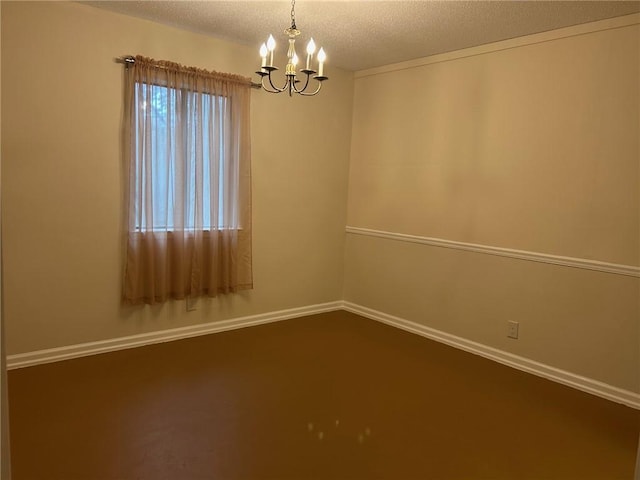 unfurnished room with a notable chandelier, baseboards, and a textured ceiling