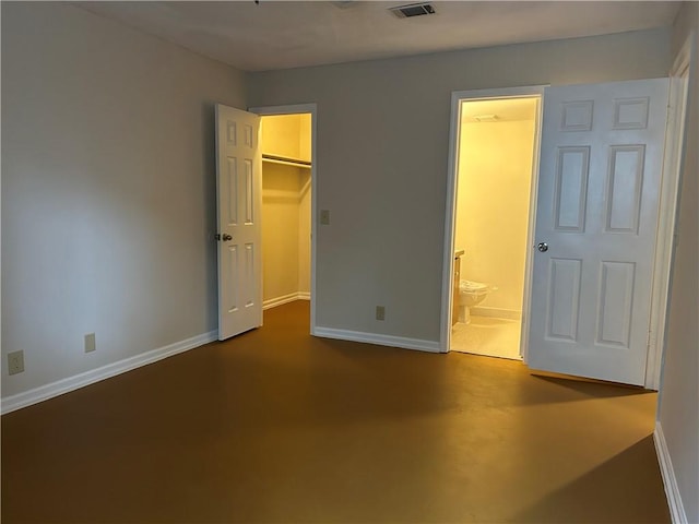 unfurnished bedroom with visible vents, baseboards, connected bathroom, and a spacious closet