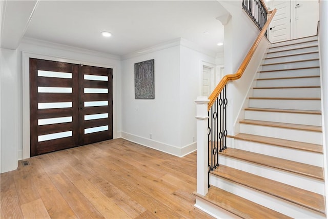 1626 Bruce Dr, Saint Simons Island, GA 31522 - foyer entrance featuring light wood finished floors, stairs, baseboards, and ornamental molding