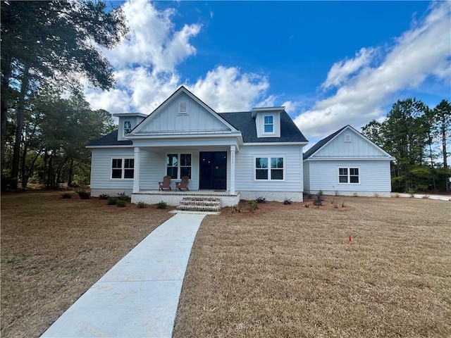 view of front of property featuring covered porch and a front yard