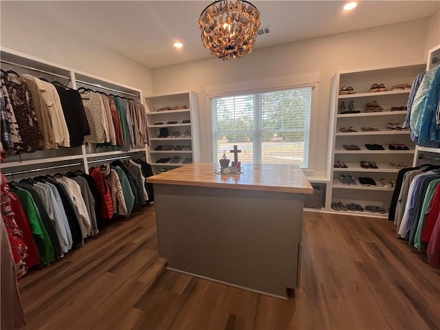 walk in closet with an inviting chandelier, visible vents, and dark wood-style flooring