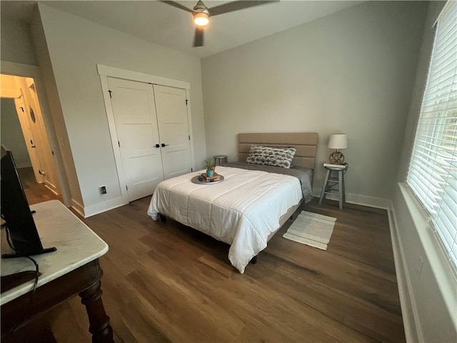 bedroom featuring ceiling fan, baseboards, dark wood finished floors, and a closet