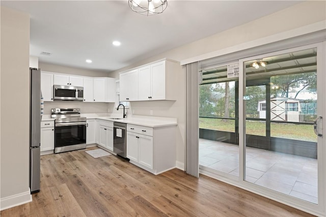 kitchen featuring white cabinetry, stainless steel appliances, light hardwood / wood-style floors, and sink