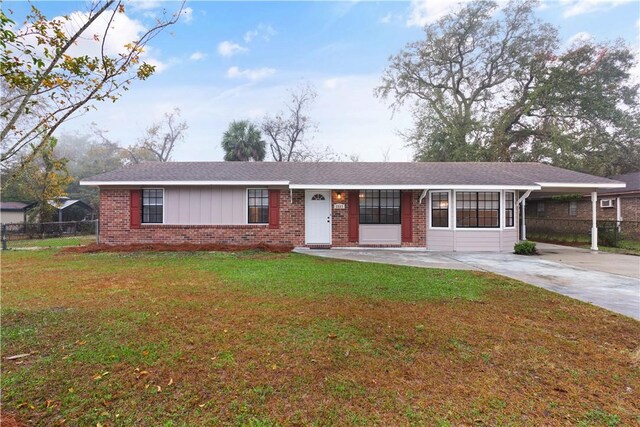 ranch-style home featuring a carport and a front lawn