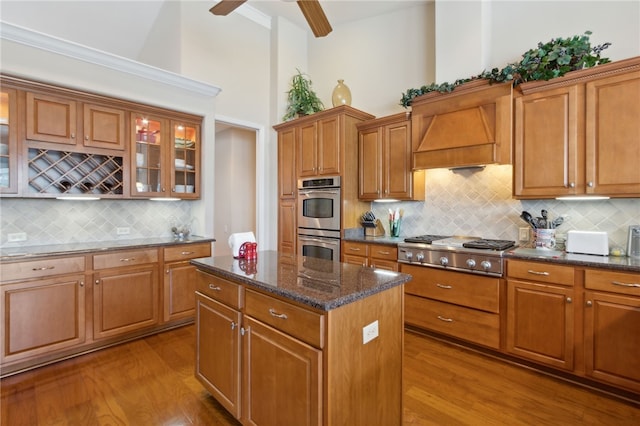 2491 Isles Of St Marys Way, Saint Marys, GA 31558 - kitchen with appliances with stainless steel finishes, premium range hood, wood finished floors, a center island, and high vaulted ceiling