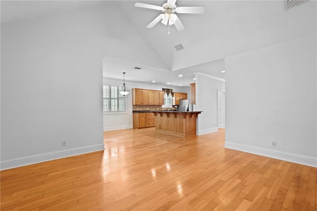 151 Raymonds Grant Trce, Saint Simons Island, GA 31522 - unfurnished living room with high vaulted ceiling, a ceiling fan, light wood-style floors, a chandelier, and recessed lighting
