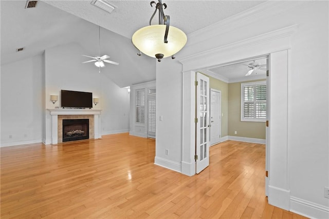 151 Raymonds Grant Trce, Saint Simons Island, GA 31522 - unfurnished living room with ceiling fan, a fireplace, light wood-type flooring, vaulted ceiling, and crown molding
