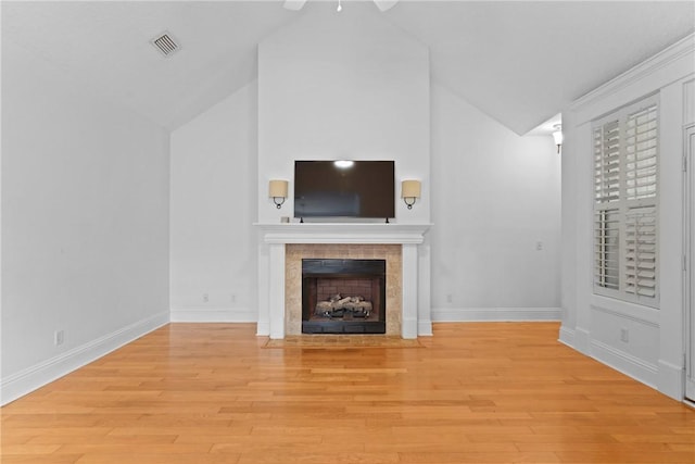 151 Raymonds Grant Trce, Saint Simons Island, GA 31522 - unfurnished living room featuring a tile fireplace, light wood finished floors, high vaulted ceiling, and a ceiling fan