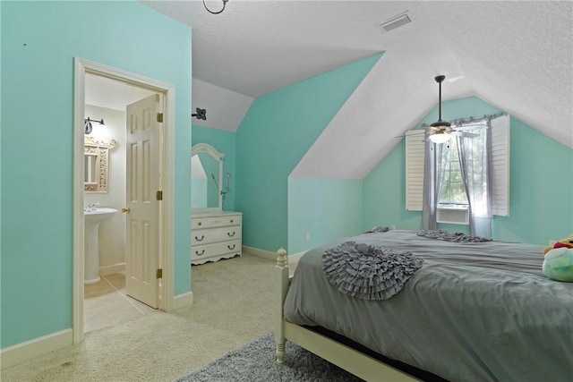 151 Raymonds Grant Trce, Saint Simons Island, GA 31522 - bedroom with lofted ceiling, carpet, a textured ceiling, and connected bathroom
