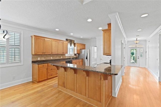 151 Raymonds Grant Trce, Saint Simons Island, GA 31522 - kitchen featuring stainless steel fridge with ice dispenser, light wood-style floors, crown molding, a peninsula, and a kitchen bar