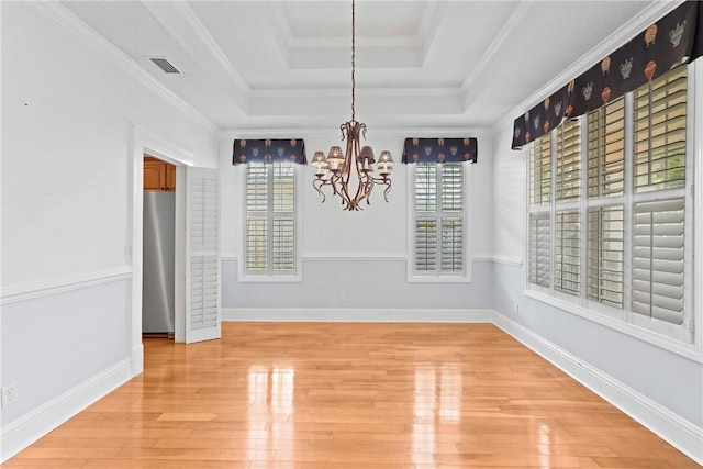 151 Raymonds Grant Trce, Saint Simons Island, GA 31522 - unfurnished dining area featuring a tray ceiling, a chandelier, light wood finished floors, and crown molding