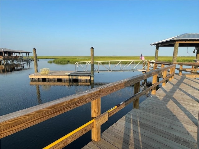 view of dock with a gazebo and a water view