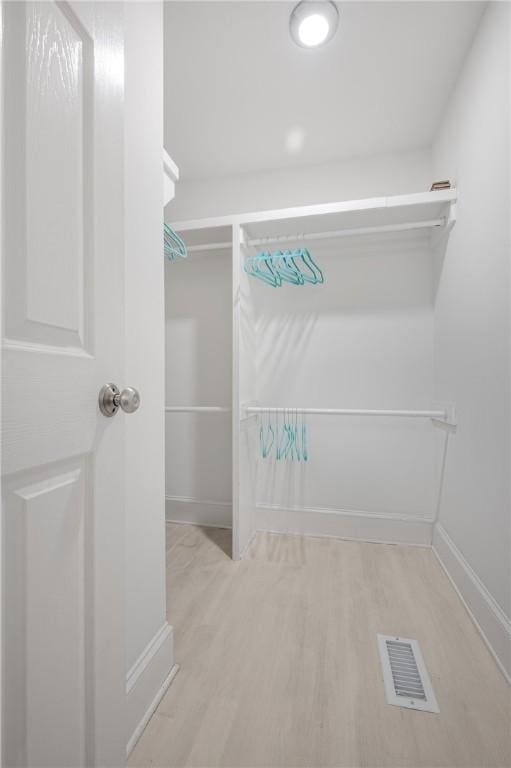 walk in closet with visible vents and wood finished floors