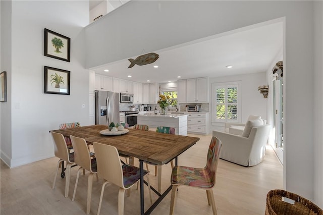 dining space with light wood-type flooring and recessed lighting