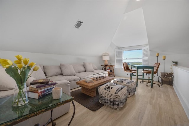 living room with vaulted ceiling, wood finished floors, and visible vents