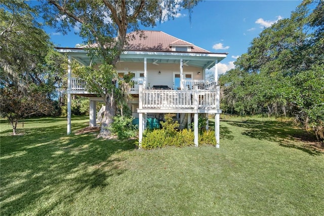 rear view of house with metal roof and a lawn