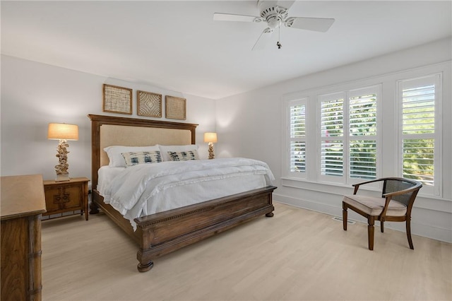 bedroom featuring light wood-style flooring, baseboards, and a ceiling fan