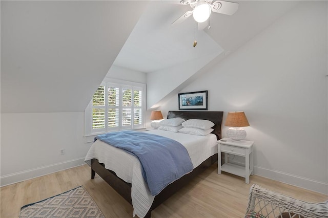 bedroom featuring lofted ceiling, light wood finished floors, a ceiling fan, and baseboards