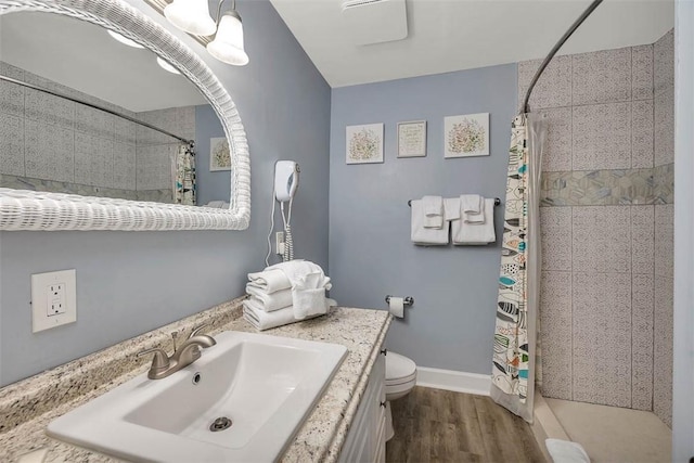 bathroom with hardwood / wood-style flooring, a shower with curtain, toilet, and vanity