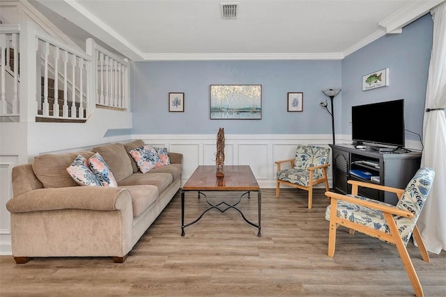 living room with light hardwood / wood-style flooring and crown molding