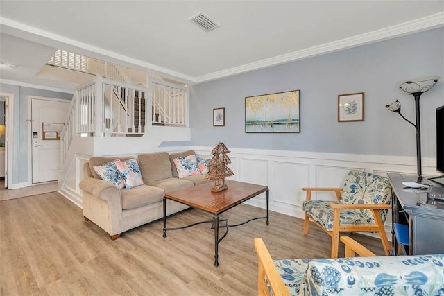 living room with light hardwood / wood-style floors and ornamental molding