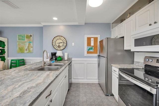 kitchen featuring white cabinetry, sink, appliances with stainless steel finishes, and ornamental molding