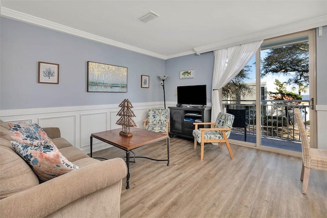 living room with crown molding and light hardwood / wood-style flooring