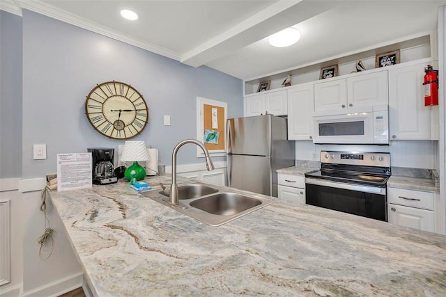 kitchen featuring sink, ornamental molding, white cabinetry, kitchen peninsula, and stainless steel appliances